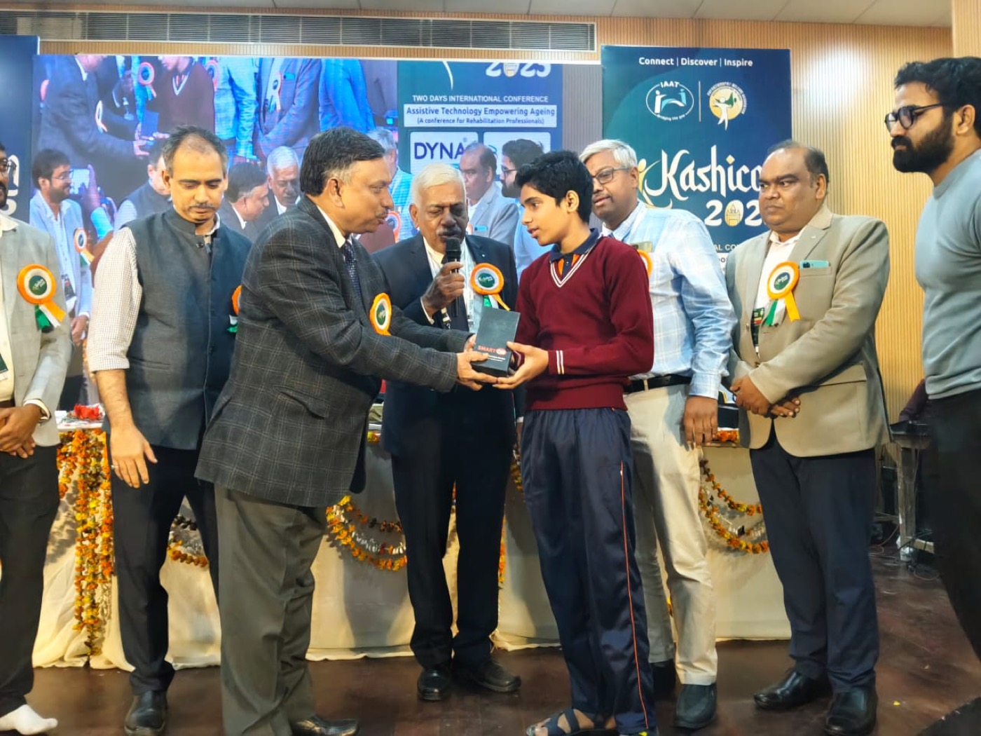A student receiving the SMARTON Kit on stage at the Kashicon international assistive-technology conference